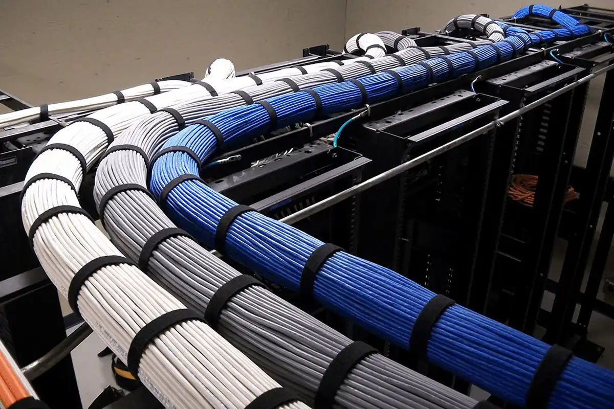 Professional structured cabling installation — neatly bundled Cat6 ethernet cable runs routed through a commercial server rack with color-coded organization, installed by Alpine IT in Colorado Springs, CO