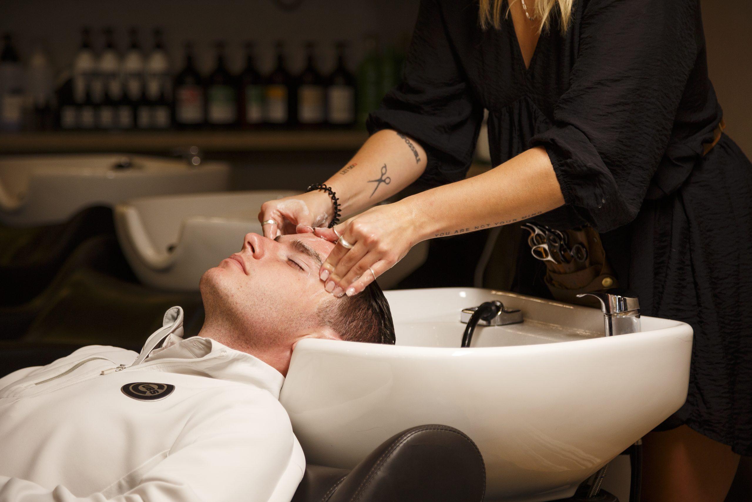 Salon stylist providing hair care service to client